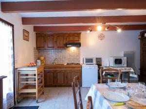 cocina con armarios de madera y mesa con mantel en Holiday Home Ty Pendruc by Interhome, en Trégunc