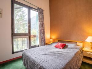 ein Schlafzimmer mit einem Bett mit einem roten Kissen darauf in der Unterkunft Apartment La Balme by Interhome in Chamonix-Mont-Blanc