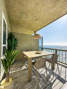 una mesa y sillas en un balcón con vistas al océano en Cozy House With Ocean View - PCH-R-MA en Malibu