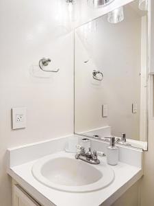 Baño blanco con lavabo y espejo en Cozy House With Ocean View - PCH-R-MA en Malibu