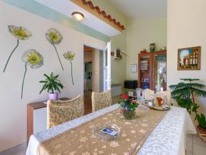 a dining room with a table and flowers on the wall at Holiday Home Nena by Interhome in Buje