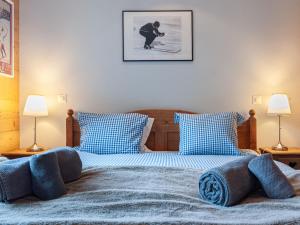 a bedroom with two beds with blue pillows at Apartment Montagnard 10 by Interhome in Nendaz