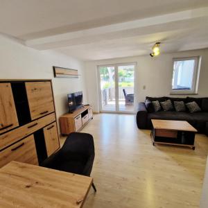ein Wohnzimmer mit einer Couch und einem Tisch in der Unterkunft DM Hotels & Apartments - Apartment Pfarrgasse 09 in Küllstedt