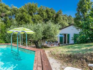 Nibbiaia的住宿－Holiday Home Podere gli Olivi by Interhome，一座房子旁带遮阳伞的游泳池