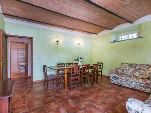Una sala de estar con una mesa y sillas y un sofá. en Apartment Podere La Madonnina-3 by Interhome, en Nibbiaia