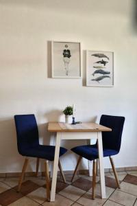 einen Esstisch mit zwei blauen Stühlen in der Unterkunft Apartment Gästehaus Alte Schule-1 by Interhome in Dargun