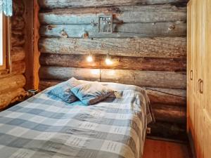ルカにあるHoliday Home Otsontupa 2 by Interhomeの木製の壁のドミトリールームのベッド1台分です。