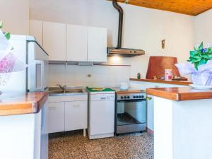 Una cocina con gabinetes blancos y un horno de estufa. en Apartment Podere La Madonnina-1 by Interhome, en Nibbiaia