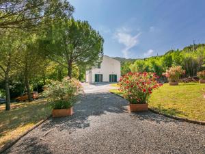 una casa con dos macetas en una entrada de grava en Apartment Podere La Madonnina-1 by Interhome, en Nibbiaia