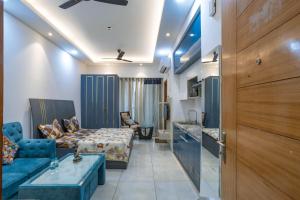 un soggiorno con divano blu e letto di LIMITLESSTRIP com- Best Stay at Central Noida #With Balcony #Free Parking #Wifi #Independent Apartment #Fully Equipped Kitchen a Noida