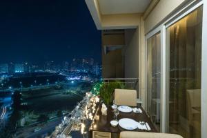 balcone con vista sulla città di notte di LIMITLESSTRIP com- Best Stay at Central Noida #With Balcony #Free Parking #Wifi #Independent Apartment #Fully Equipped Kitchen a Noida