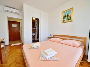 a bedroom with a bed with two towels on it at Apartment Jelka-2 by Interhome in Trstenik