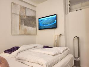 ビッソーネにあるApartment Lago di Lugano-4 by Interhomeのベッド2台と壁掛けテレビが備わる客室です。