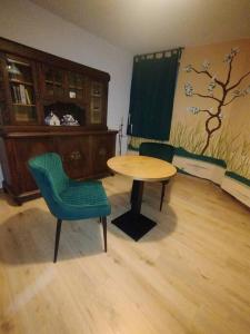 a room with a table and a green chair at Appartement Zentrumsnah Hochwertig Leipzig in Leipzig