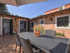 a wooden table with chairs and a potted plant on a patio at Holiday Home Tramuntana by Interhome in Moscari