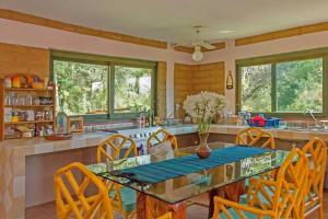 cocina con mesa de cristal y sillas en La Troje Cabañas, en Tepoztlán