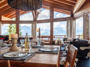 a dining room with a table and a large window at Chalet Sebas by Interhome in Nendaz
