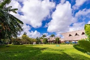 ein grünes Feld mit einem Gebäude im Hintergrund in der Unterkunft Hacienda Ixtlan Cozumel in Cozumel