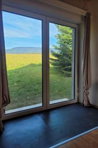 a room with a window with a view of a field at Holiday Home Holiday Hill 65 by Interhome in Lauterwasser