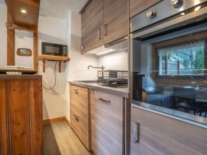 a kitchen with wooden cabinets and a large window at Apartment Clos des Outannes by Interhome in Chamonix