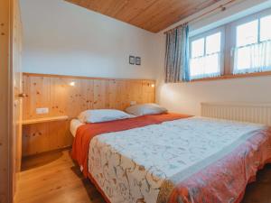 a bedroom with a bed and a large window at Chalet Königsleiten 1 by Interhome in Königsleiten