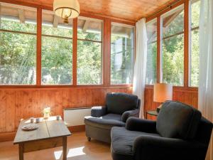 a living room with two chairs and a table and windows at Chalet Dufaux by Interhome in Champex