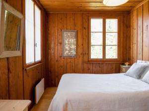 una camera con un letto bianco e due finestre di Chalet Dufaux by Interhome a Champex-Lac