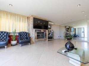 a living room with two chairs and a glass table at Holiday Home Masia Blanca by Interhome in Comarruga