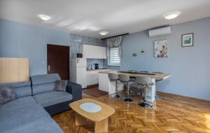 a living room with a couch and a table and a kitchen at Apartments Drazen in Crikvenica