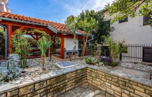 a home with a stone retaining wall and a garden at Apartments Drazen in Crikvenica