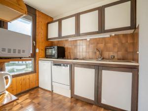 a kitchen with white cabinets and a sink at Apartment Le Prarion by Interhome in Les Houches