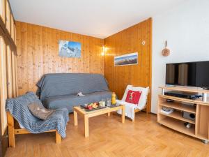 a bedroom with a bed and a tv and a table at Apartment Le Prarion by Interhome in Les Houches