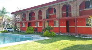 - un bâtiment rouge avec une piscine en face dans l'établissement FINCA LA VIRGEN DE PIEDRA ATLIXCO, à Atlixco