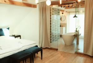 a bedroom with a tub and a bed and a bathroom at FORREST in Polanica-Zdrój