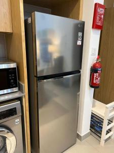 a refrigerator in a kitchen next to a microwave at Sharjah Brand New Apartment in Sharjah