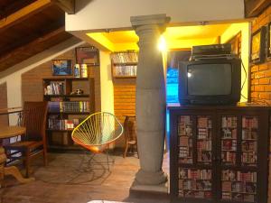 a living room with a tv and a book shelf at Hermoso LOFT rustico in Tenancingo de Degollado