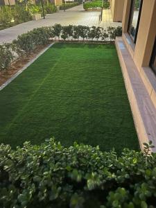 a yard of green grass in front of a building at Sharjah Brand New Apartment in Sharjah