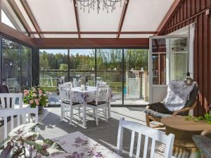 une véranda avec une salle à manger dotée d'une table et de chaises dans l'établissement Holiday Home Villa Blommelund by Interhome, à Kolmården