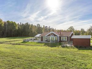 una casa en un campo con el sol en el cielo en Holiday Home Villa Blommelund by Interhome, en Kolmården
