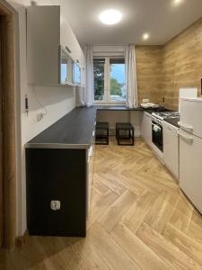 a kitchen with a black counter top and wooden floors at Apartament KaMaRo in Słubice