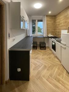 a kitchen with a black counter top and wooden floors at Apartament KaMaRo in Słubice +17 photos
