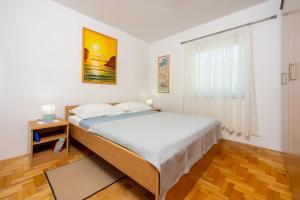 Un dormitorio con una cama grande y una ventana en Apartments Petak, en Dramalj