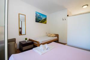 a small room with two beds and a mirror at Apartments Jelena in Bogomolje