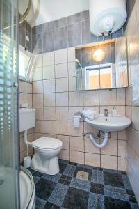 a bathroom with a toilet and a sink at Apartments Jelena in Bogomolje