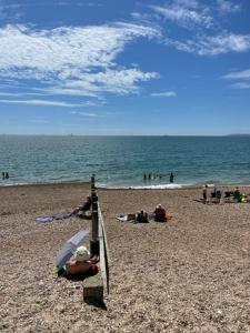 a group of people on a beach with an umbrella at The Beach House in South Hayling