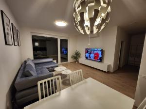 a living room with a blue couch and a tv at BA Apartment with free garage parking, huge outside area in Bratislava