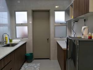 a kitchen with a refrigerator and a sink and windows at MiahPuteh Cozy Homestay Cameron Highlands Pasar Malam in Brinchang +17 photos