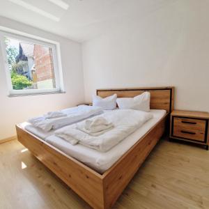 1 dormitorio con 1 cama con sábanas blancas y ventana en DM Hotes & Apartments - Apartment Pfarrgasse 09, en Küllstedt