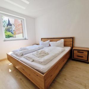 ein Schlafzimmer mit einem Bett mit weißen Laken und einem Fenster in der Unterkunft DM Hotels & Apartments - Apartment Pfarrgasse 09 in Küllstedt + 31 Fotos