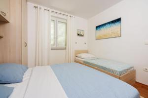 - une chambre avec 2 lits et une fenêtre dans l'établissement Apartments Petak Novi, à Dramalj